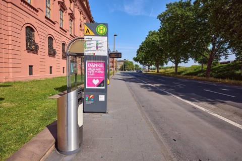 Landtag bus stop, New Armoury, historic building, public trash can, lantern, trees, lawn, blue sky,