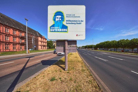 Welcome to Gutenberg City, tourist sign, roads, lanes, central island, lantern, trees, lawn, blue