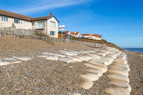 For Sale estate agent signs outside houses at risk of coastal erosion, Thorpeness, Suffolk, North