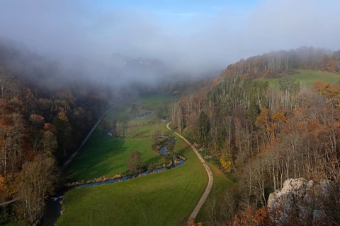 Autumn landscape with rising fog over the Grosse Lauter river loop in Lautertal at sunrise. View