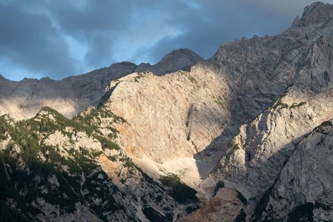 The warm evening sun falls on the steep rock faces of the Kamnik-Savinjer Alps near Zgornje