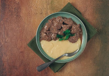 Liver beef stroganoff with mashed potatoes, table setting in green tones, homemade