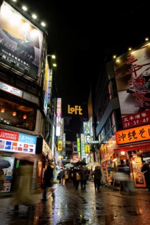 Busy pedestrian zone with many shopping centers and stores, illuminated with lots of neon signs at