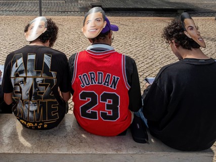 Street art, young people with Ronaldo mask on the back of their heads taking part in a school