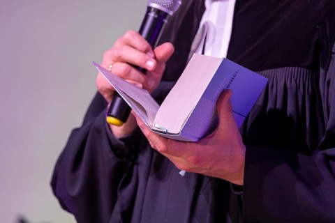 Protestant priest holding a Bible (church symbol)