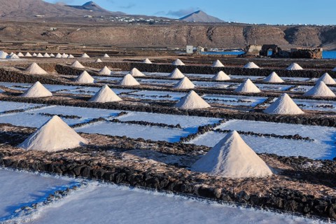 Small conical mounds of sea salt in historic saline for salt production Las Salinas de Janubio,