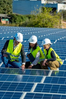 Diverse team of engineers and technicians inspecting and discussing solar panel installation and
