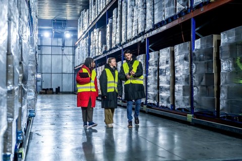 Diverse logistics team is walking and discussing inventory management within a modern cold storage