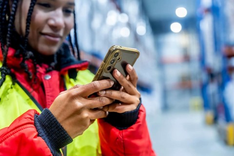 Logistics professional checking inventory with a mobile phone, optimizing cold chain operations and