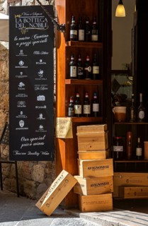 Italian wine shop with wine bottles and wooden boxes in rustic surroundings, Tuscany, Italy