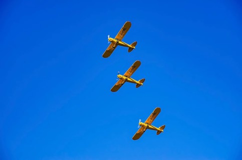 Three Piper PA-18 Super Cub aircraft from the Bravo Lima Formation flying group in formation flight