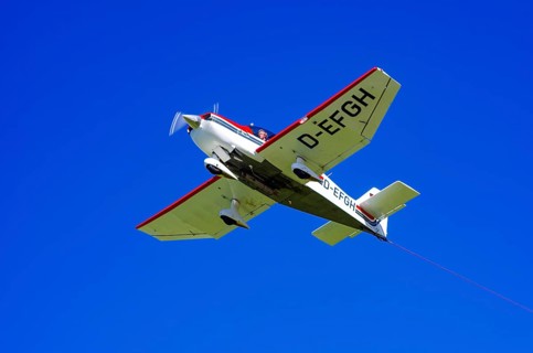 A Robin DR 400/200R Remorqueur light aircraft, registration D-EFGH, tows a glider during a flight
