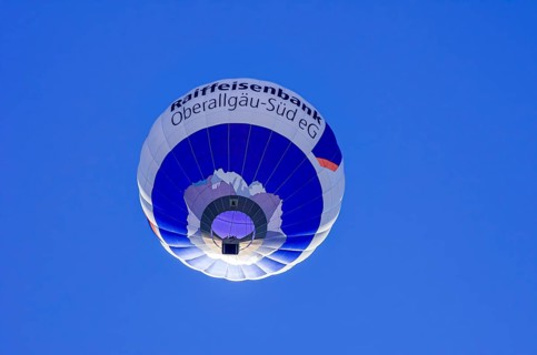 A hot air balloon, registration D-OASF, rises into the air as part of an air show at the