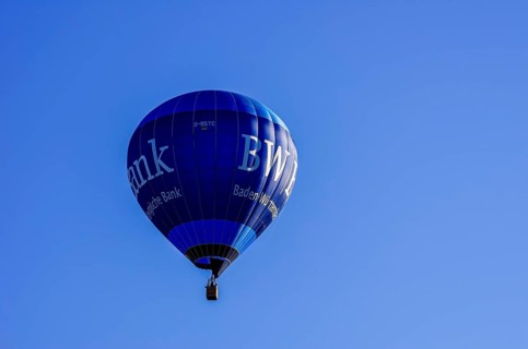 A hot air balloon, registration D-OSTC, rises into the air as part of an air show at the Rossfeld
