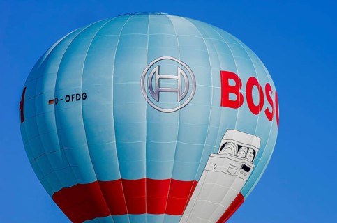 A hot air balloon, registration D-OFDG, rises into the air as part of an air show at the