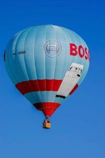 A hot air balloon, registration D-OFDG, rises into the air as part of an air show at the
