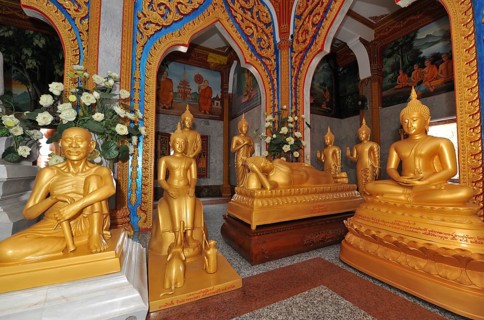 Prayer room devotional room with golden statues from left Monk and Buddha in the temple complex Wat