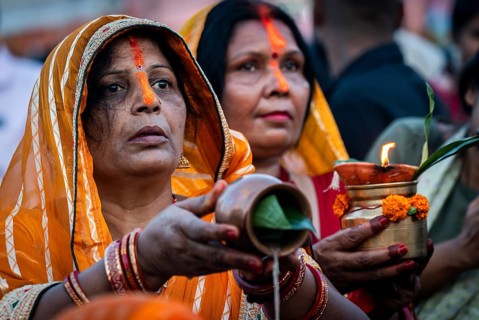 Hindu devotees offer prayers to the Sun God on the bank of Brahmaputra river on the occasion of