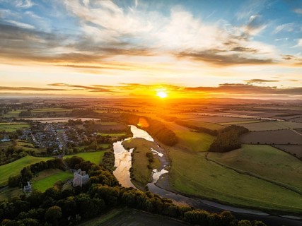 Sunset over Norham Castle and River Tweed from a drone, Norham, Northumberland, England, United