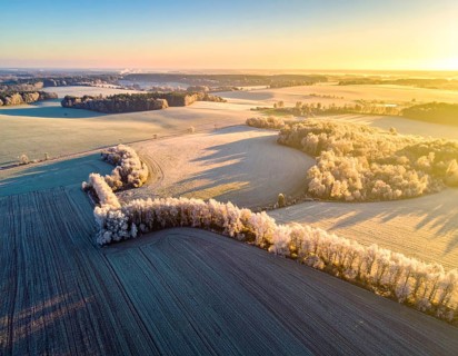 Bird Eye Perspective of Frost Covered Farmland. Seasonal Agricultural Scenery, winter and autumn