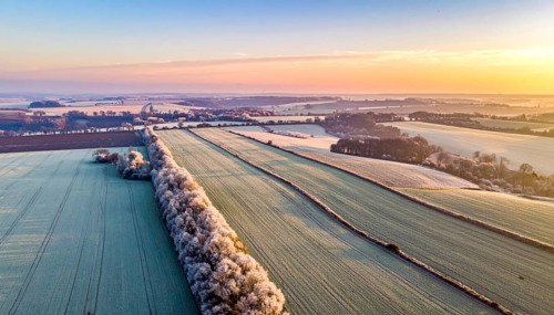 Bird Eye Perspective of Frost Covered Farmland. Seasonal Agricultural Scenery, winter and autumn