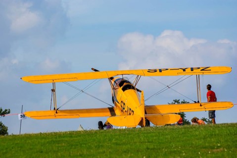 A Bücker Bü 131 Jungmann biplane parked at the edge of the airfield, SP-YPZ registration, as part