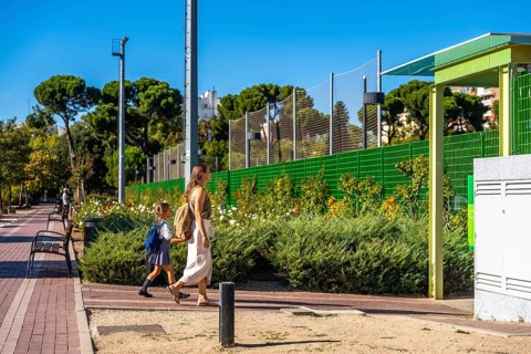 Mother and daughter walking together on a sunny day, the young student wearing a backpack and
