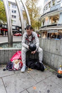 Man in public consumes laughing gas filled into a balloon with a gas cartridge, still legal