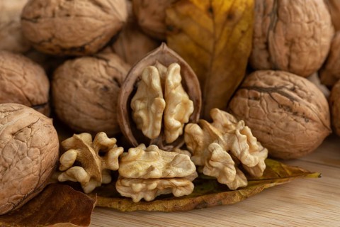 Fresh, delicious walnuts from Germany with leaves on a wooden board