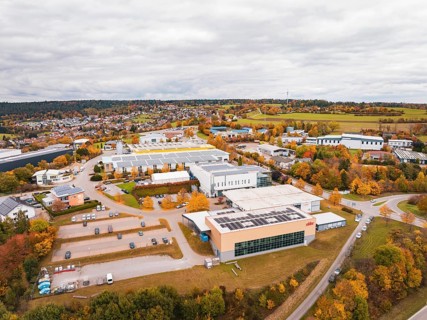 Industrial buildings and warehouses in a landscape with autumn trees and cloudy sky, Dornstetten,
