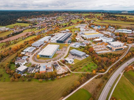 Extensive industrial area with autumn trees and buildings seen from an aerial perspective,