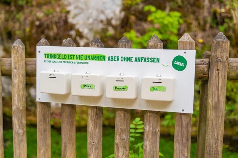 Sign on a wooden fence with a humorous message about tips, Wimsener Höhle, Hayingen, Germany