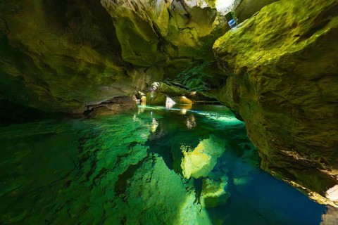 Enchanting cave with glowing water and natural rock structures in the underground, Wimsener Höhle,