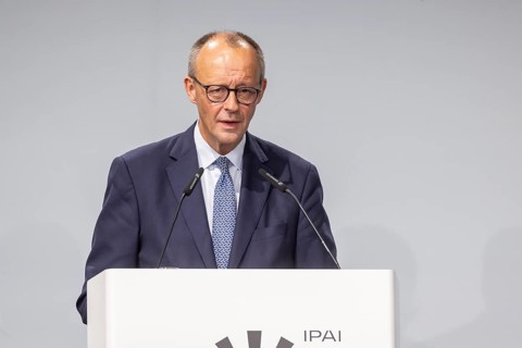 Federal Chancellor Friedrich Merz (CDU) . Portrait at the lectern with free text space.