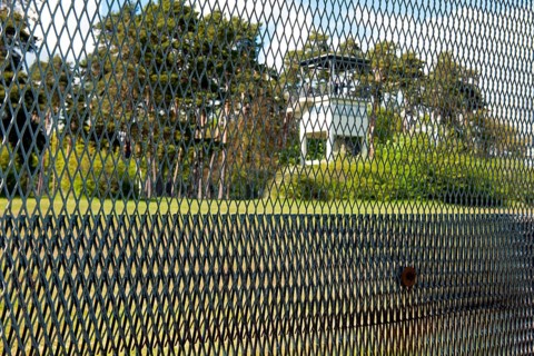 View of former area of the GDR through original GDR border fence from 1970s with death strips on