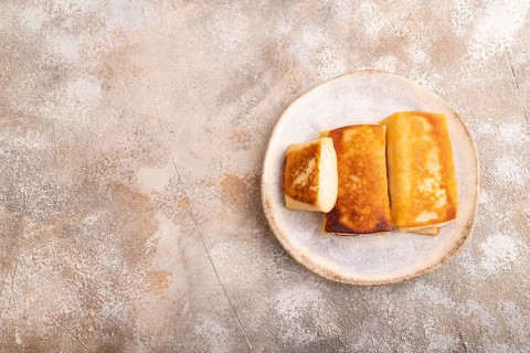 Fried crispy pancakes with meat and cheese on brown concrete background. top view, flat lay, copy