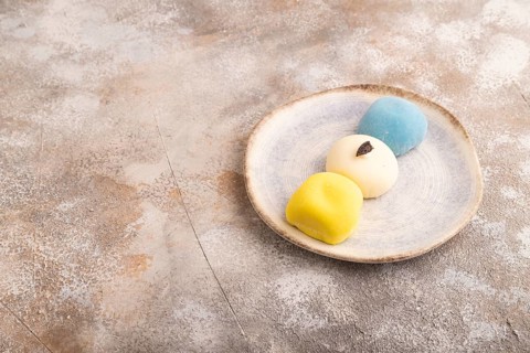 Japanese Mochi Cakes on brown concrete background, side view, copy space