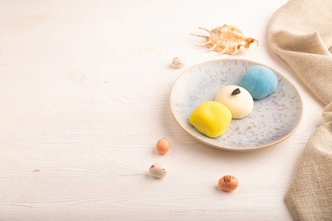 Japanese Mochi Cakes on white wooden background and linen textile, side view, copy space