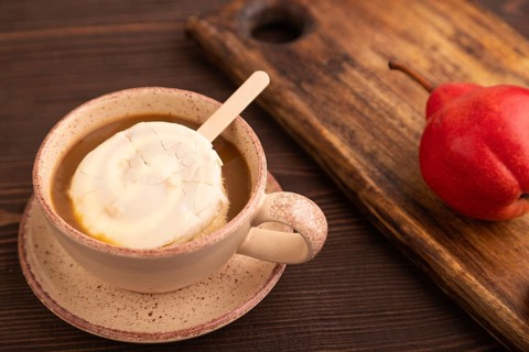 ?hocolate Ice cream in white glaze, cup of coffee, on brown wooden background, side view, close up,
