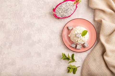 White ?ottage cheese, Curd, with Pithaya on gray concrete background and linen textile, top view,
