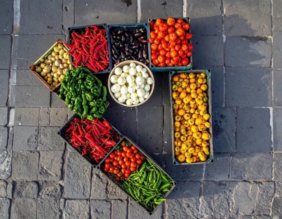 Traditional Mexican plaza with crates of peppers, onions, and tomatoes, economic prosperity in