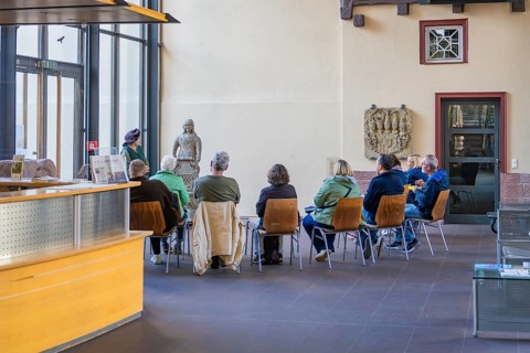 Group of people sitting in a museum room looking at sculptures, Urschelherbst Street Festival,
