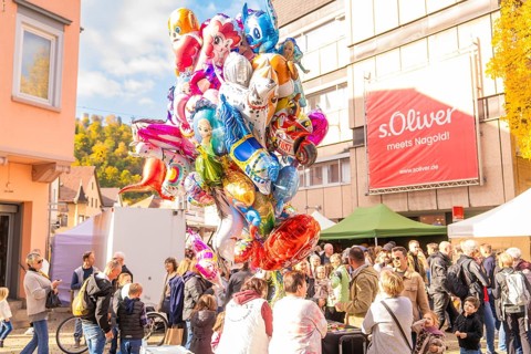 Large collection of colorful balloons above a crowd in sunny autumn weather, Urschelherbst street