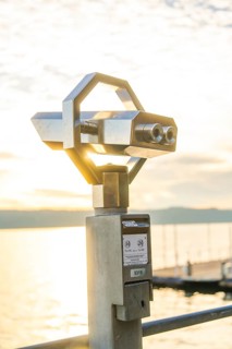 Modern metal binoculars with a view of the lake at sunrise, Überlingen, Lake Constance, Germany