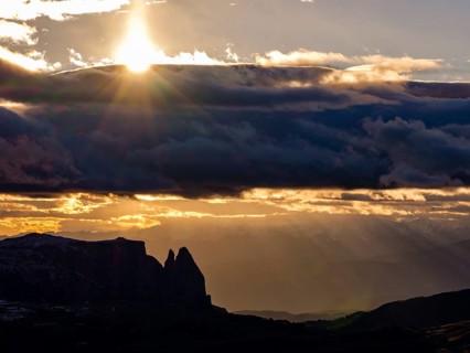View of the Sciliar under dark clouds with sun, Dolomites, Trentino, South Tyrol, Italy