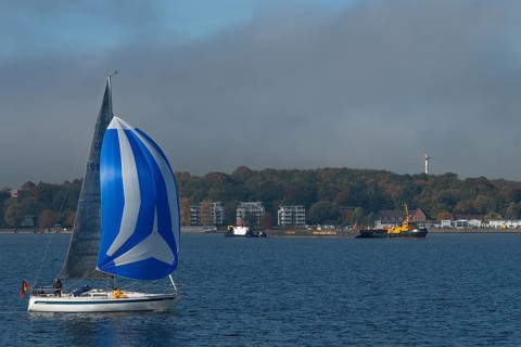 Kiel Fjord, Holtenau district, sailing yacht with spinnaker, tugboat, modern buildings, Kiel,