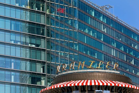 Historic Café Kranzler logo with modern office building and H&M logo on Kurfürstendamm,