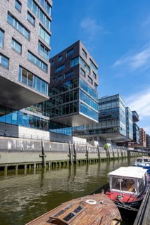 Modern residential buildings, boats at the traditional shipping harbor on Sandtorkai, behind