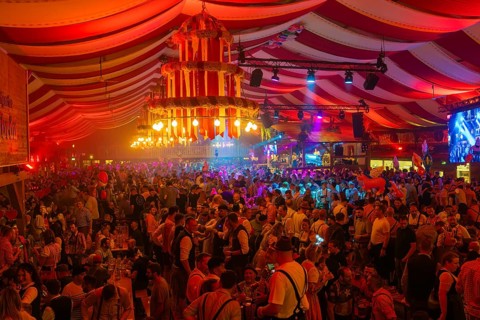 Lively and colourful celebration in a large beer tent full of people and bright decorations,