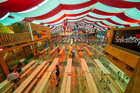 Large marquee with red ceilings and wooden benches, Bavarian atmosphere and decoration, Volksfest